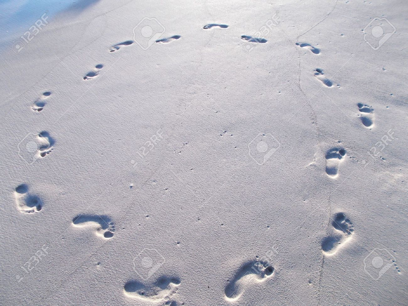 21816641-Footprints-in-circle-on-wet-beach-sand-Stock-Photo.jpg