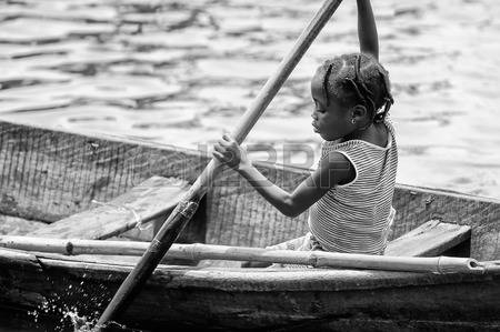 61498326-porto-novo-benin-mar-9-2012-unidentified-beninese-little-girl-rows-a-wooden-boat-people-of-benin-suf.jpg