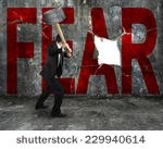 stock-photo-businessman-holding-sledgehammer-hitting-red-fear-word-on-concrete-wall-with-large-blank-hole-229940614.jpg