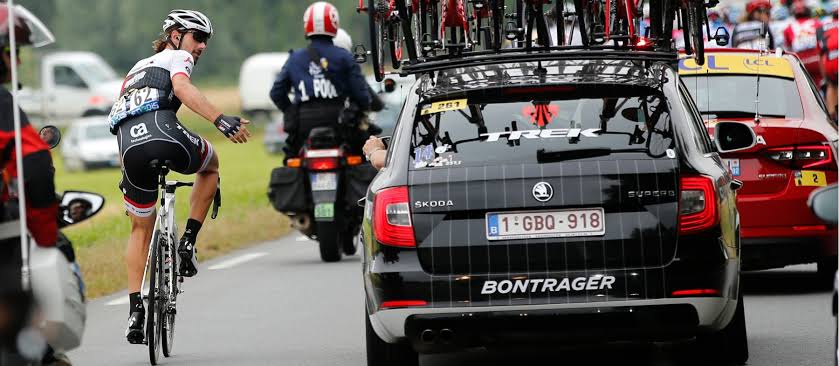 A man on his bicycle looks at a car with envy.jpg
