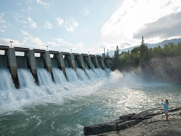 woman-takes-pic-of-water-flowing-through-hydro-dam-picture-id505666993.jpg