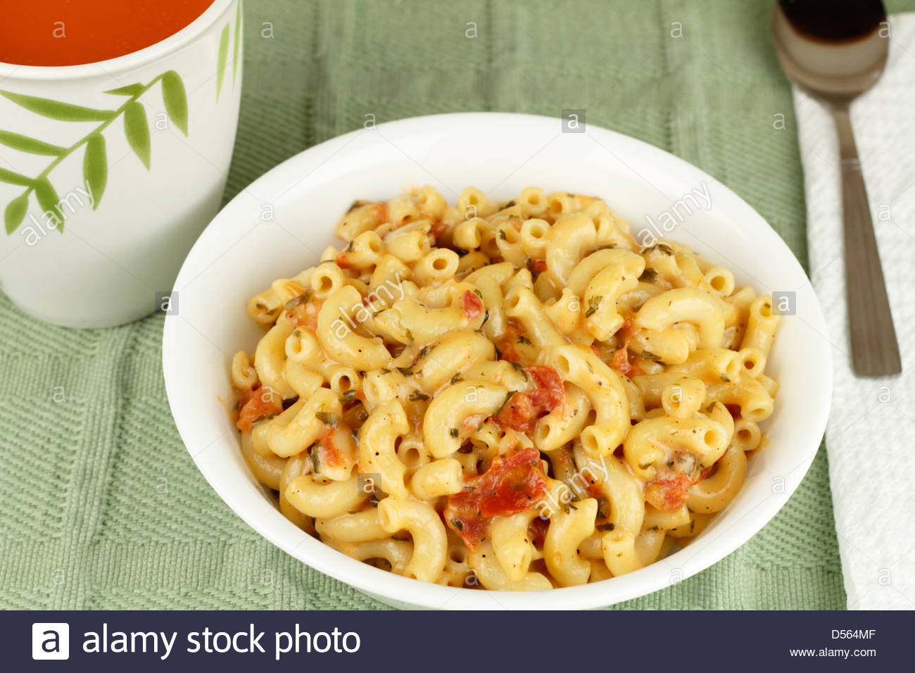 taca-branco-de-um-cotovelo-macarrao-misturado-com-queijo-parmesao-derretido-tomate-em-cubos-as-ervas-italianas-com-um-lado-de-tomate-vegetais-massas-alimenticias-com-tomates-d564mf.jpg