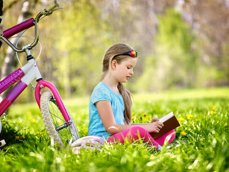 bikes-cycling-girl-wearing-helmet-kid-child-rides-bicycle-reading-book-near-bicycle-park-outdoor-good-70281006.jpg