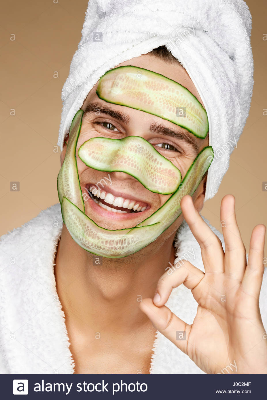 funny-man-receiving-facial-mask-of-cucumber-and-showing-okay-gesture-J0C2MF.jpg