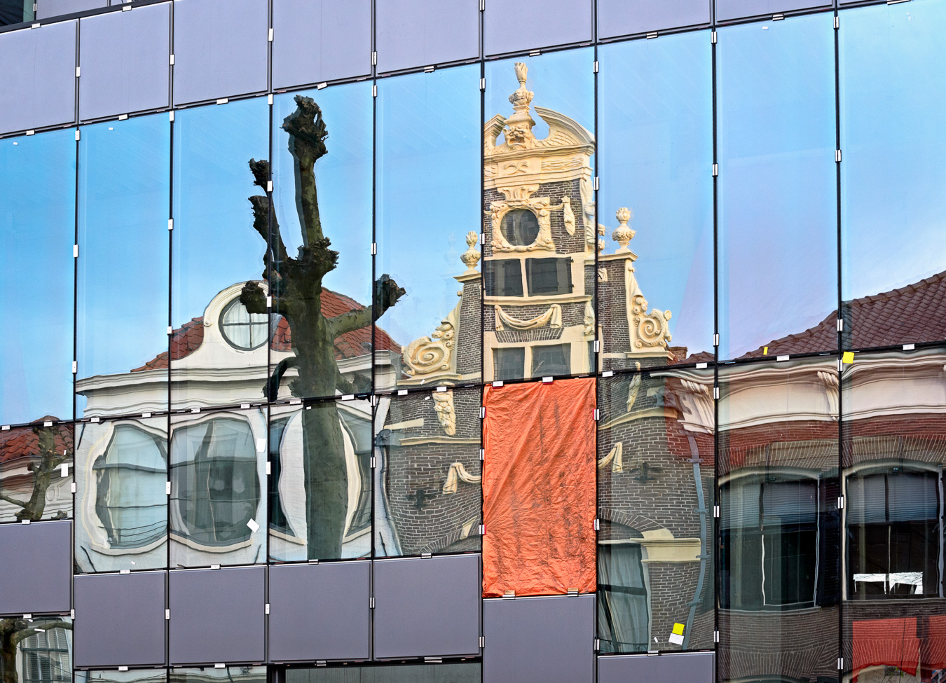 Reflections of old buildings in a new modern building