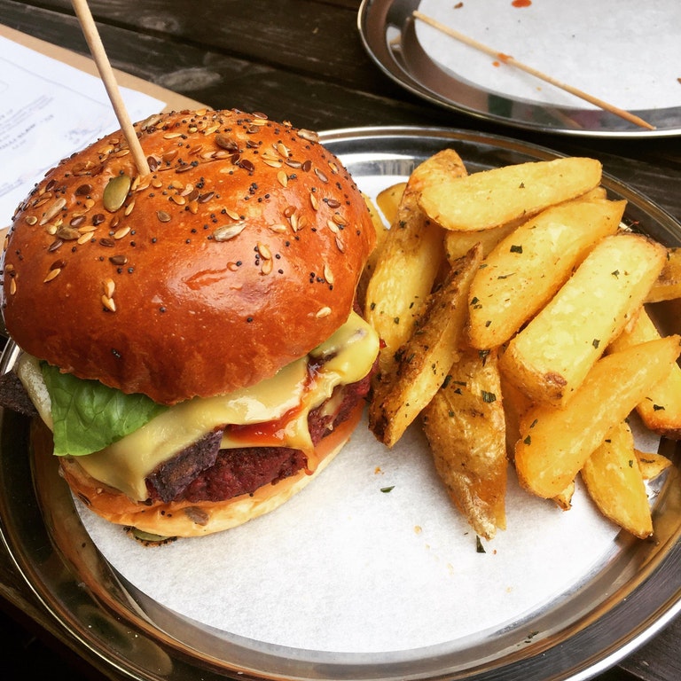 yummy And Tasty  this amazing burger; a handmade beetroot and butter bean patty with guacamole, 'cheese', salsa, chilli jam, tortilla chips, lettuce & onion on a seeded bun..jpg