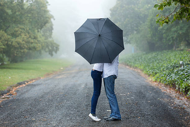 couple-kissing-behind-the-umbrella-picture-id475903714.jpg