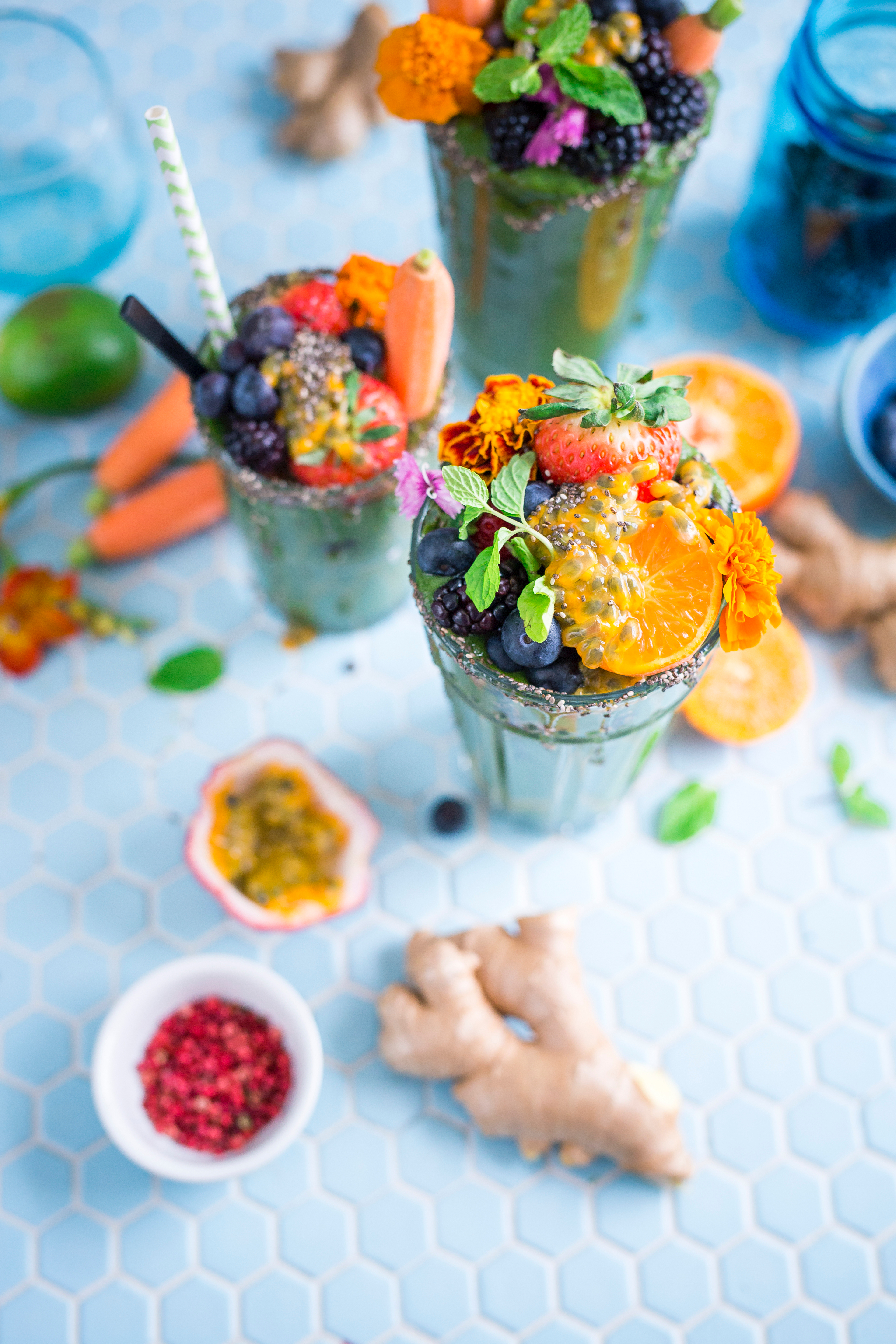 Green fruit smoothie with straws on blue table.jpg