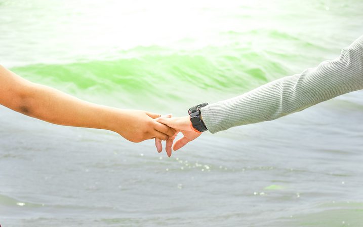 couple-holding-hands-by-ocean.jpg