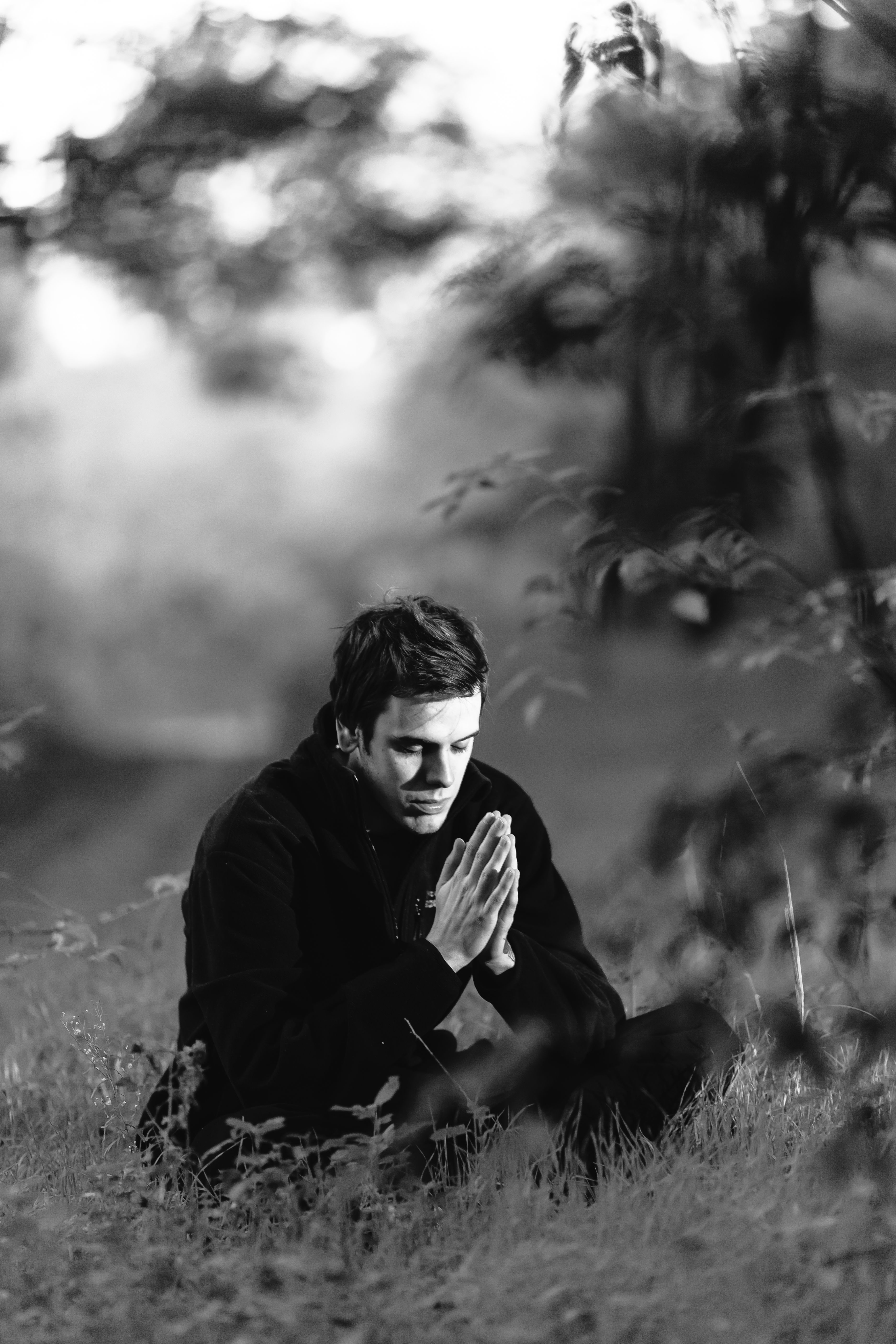 В поисках размышления. Мужчина на природе. Задумчивый мужчина на природе. Мужчина сидит в лесу. Человек молится на природе.