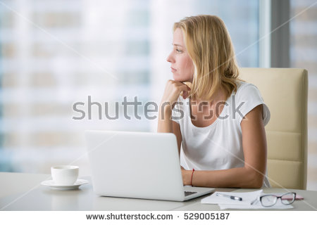stock-photo-young-attractive-woman-at-a-modern-office-desk-working-with-laptop-looking-at-the-window-529005187.jpg