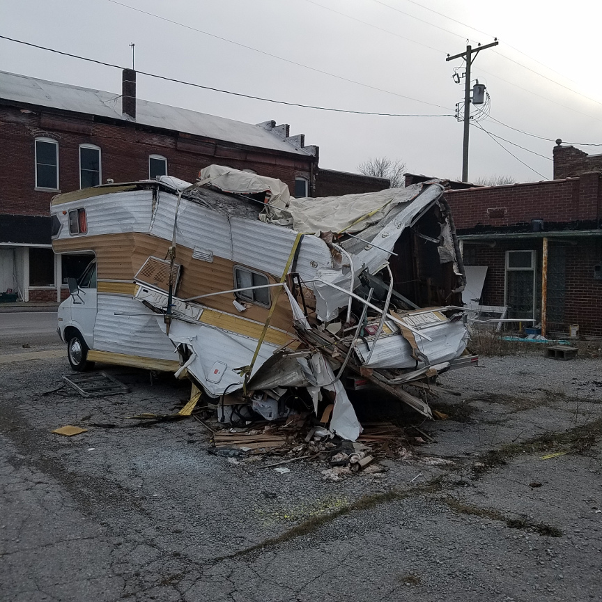 A smashed up camper from the back driver's side corner