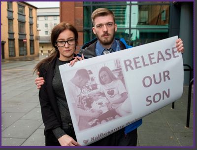 parents holding sign - release our son