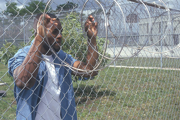 inmate-at-barbed-wire-fence-dade-county-mens-correctional-facility-picture-id144078547.jpg