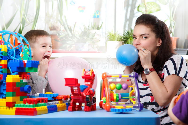 mom-helps-son-to-inflate-balloons-home-interior-51820670.jpg