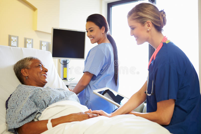 nurse-digital-tablet-talks-to-woman-hospital-bed-smiling-each-other-reassuring-patient-35795000.jpg