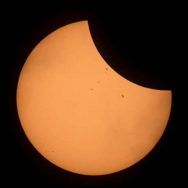 The-International-Space-Station-is-seen-in-silhouette-as-it-transits-the-sun-during-a-partial-solar.jpg