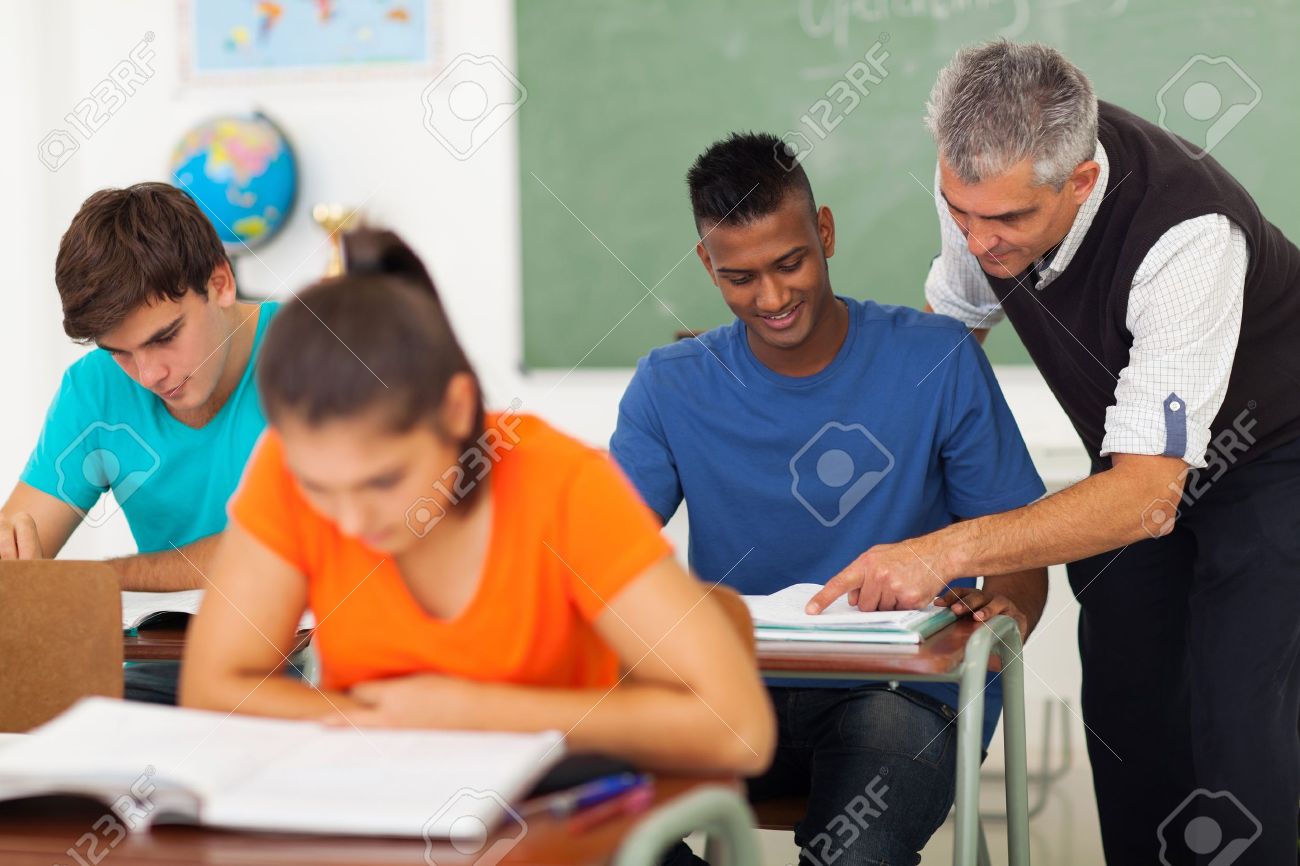 20235302-senior-high-school-teacher-helping-student-in-classroom-Stock-Photo.jpg