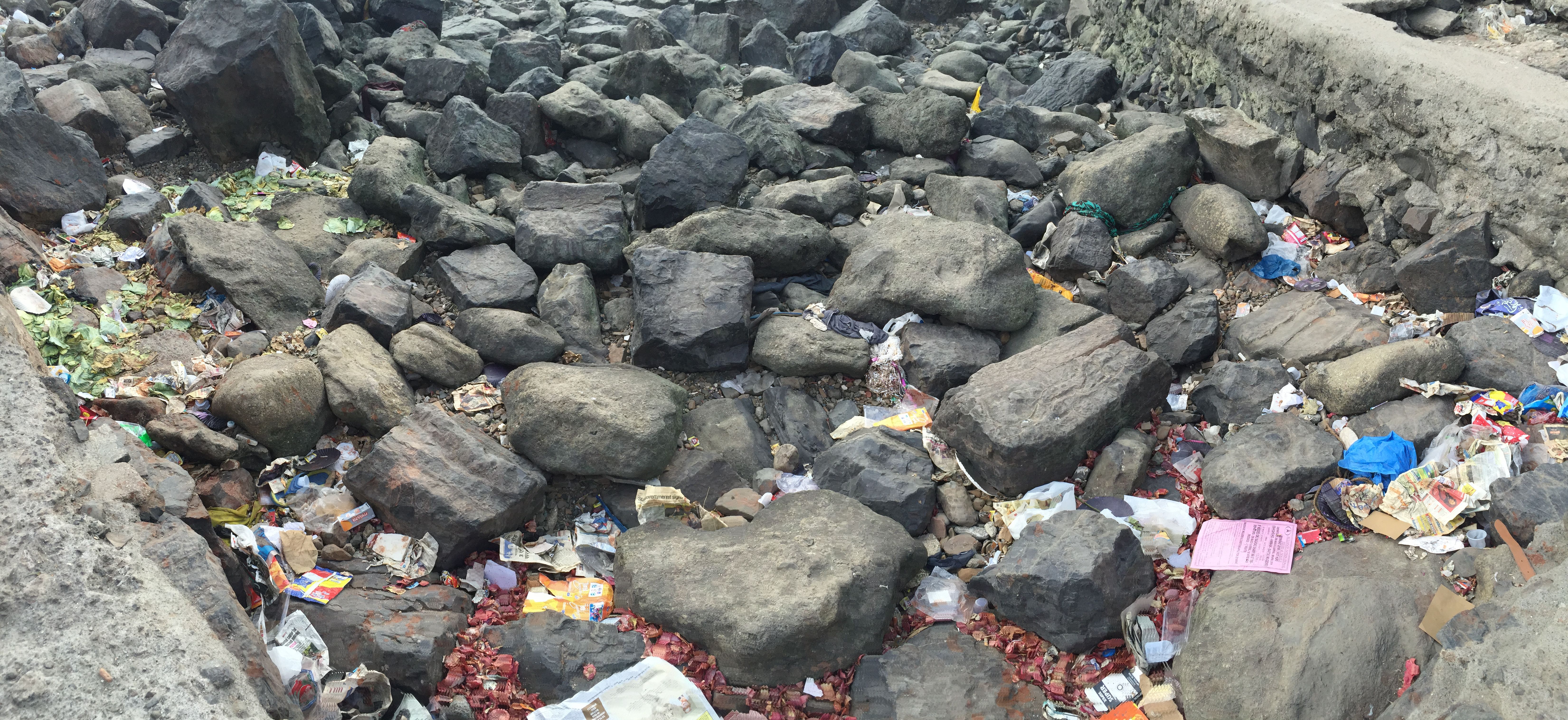 Trash next to the Haji Ali shrine on a dirty beach in Mumbai.JPG