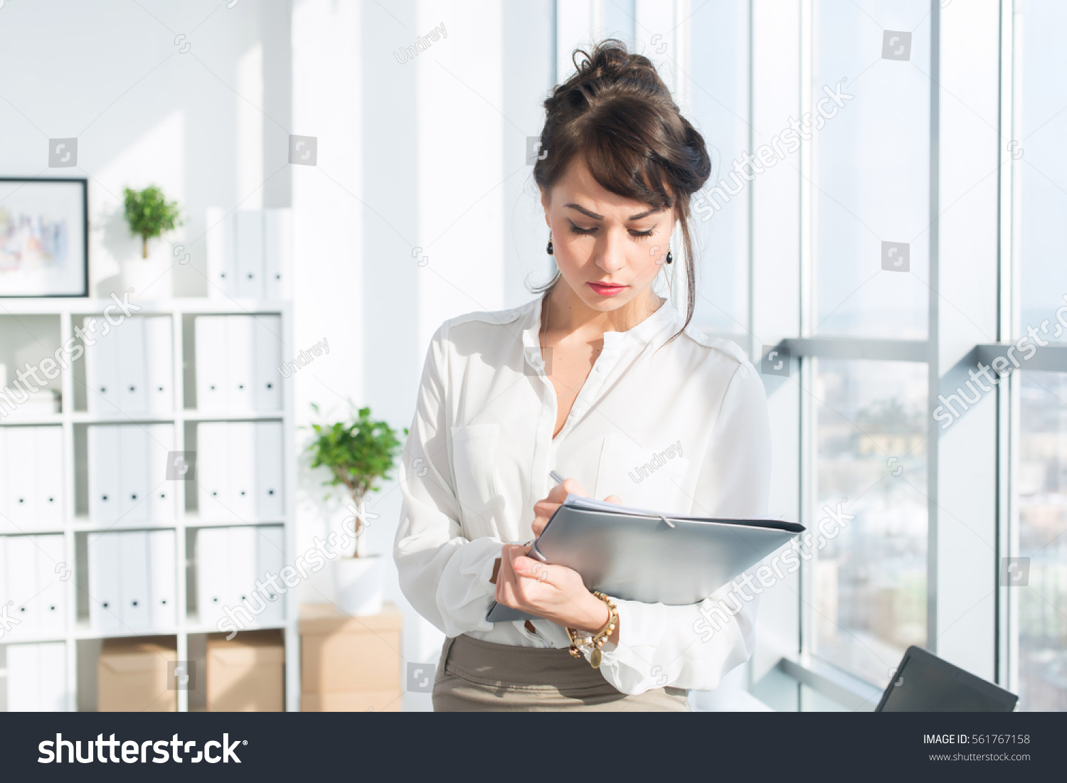 stock-photo-close-up-portrait-of-a-caucasian-female-office-assistant-at-her-workplace-confident-clerk-561767158.jpg