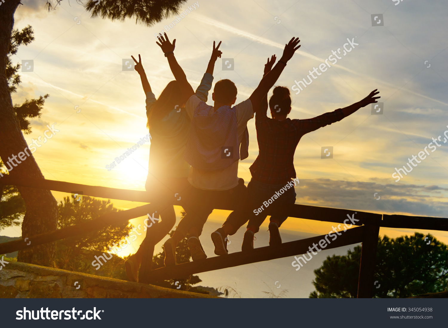 stock-photo-rear-view-of-three-couple-best-friends-travelers-put-hands-up-at-sunset-young-relaxing-hipster-345054938.jpg