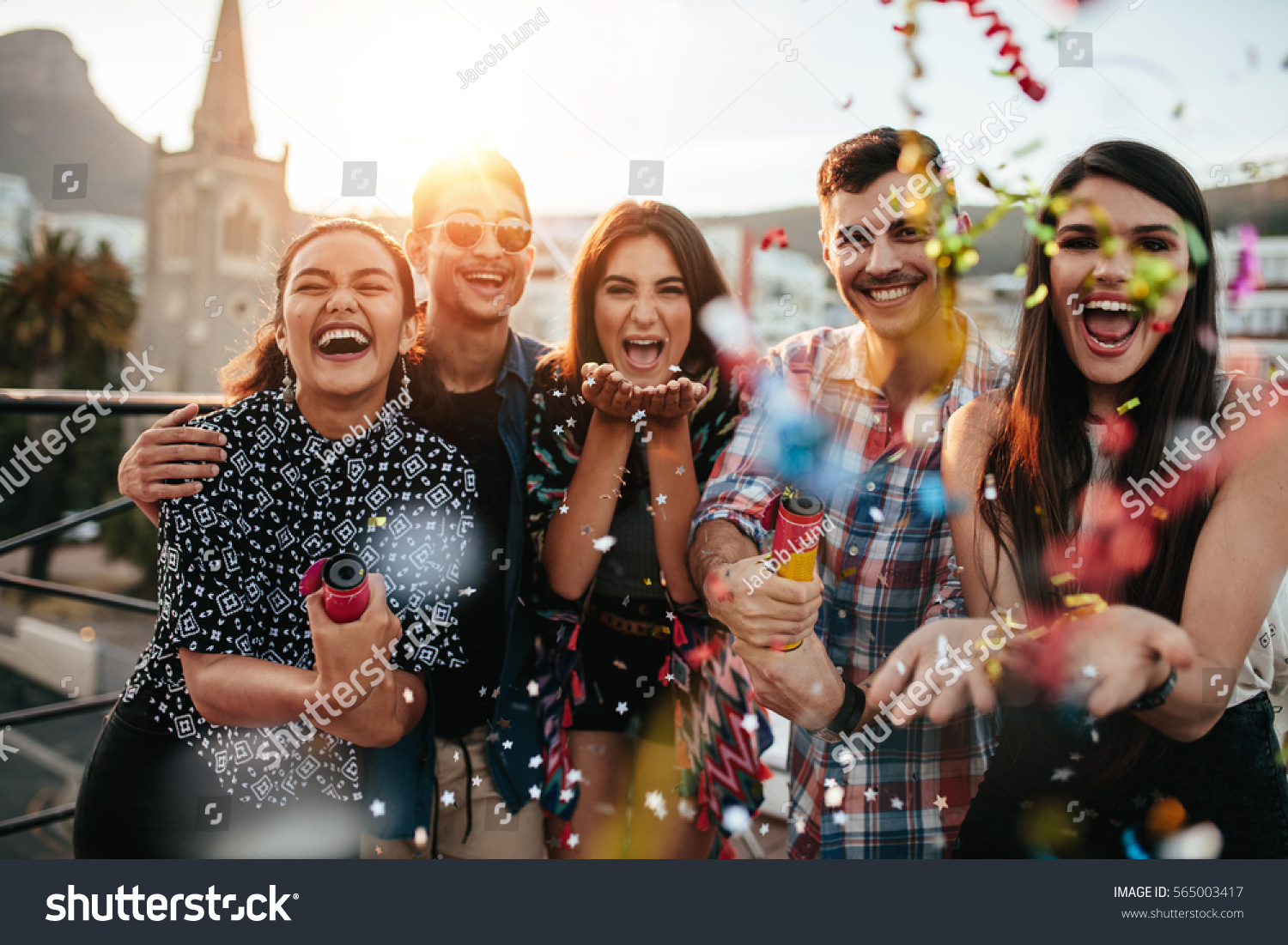 stock-photo-group-of-friends-enjoying-party-and-throwing-confetti-friends-having-fun-at-rooftop-party-565003417.jpg