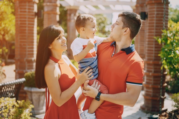 hermosa-familia-en-rojo-caminando-por-la-calle-y-el-parque_1157-4609.jpg