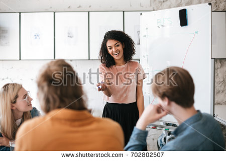 stock-photo-beautiful-african-american-lady-with-dark-curly-hair-standing-near-board-and-happily-discussing-new-702802507.jpg