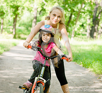 moeder-en-dochter-die-een-fiets-leren-te-berijden-59449367.jpg