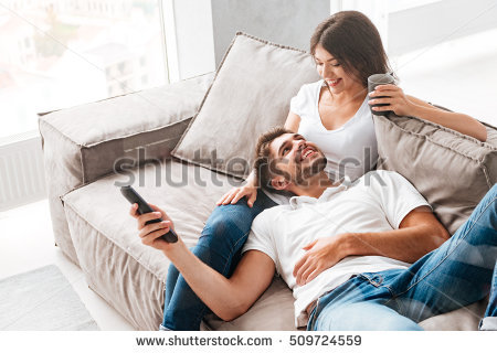 stock-photo-cheerful-beautiful-young-couple-drinking-coffee-and-watching-tv-at-home-509724559.jpg