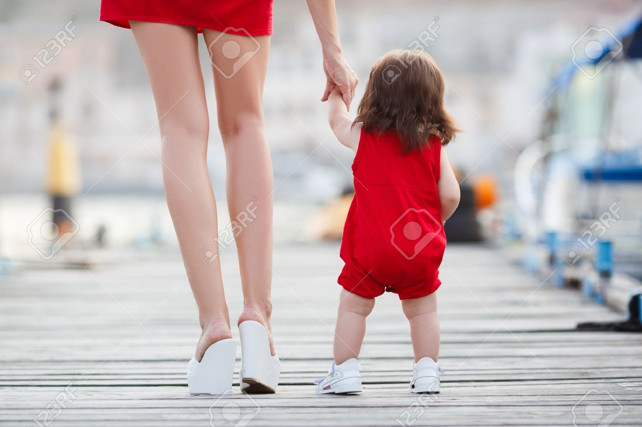 45090777-hermosa-madre-está-caminando-en-el-muelle-con-su-pequeña-hija-niña-con-los-primeros-pasos-primeros-pasos-mad-Foto-de-archivo.jpg