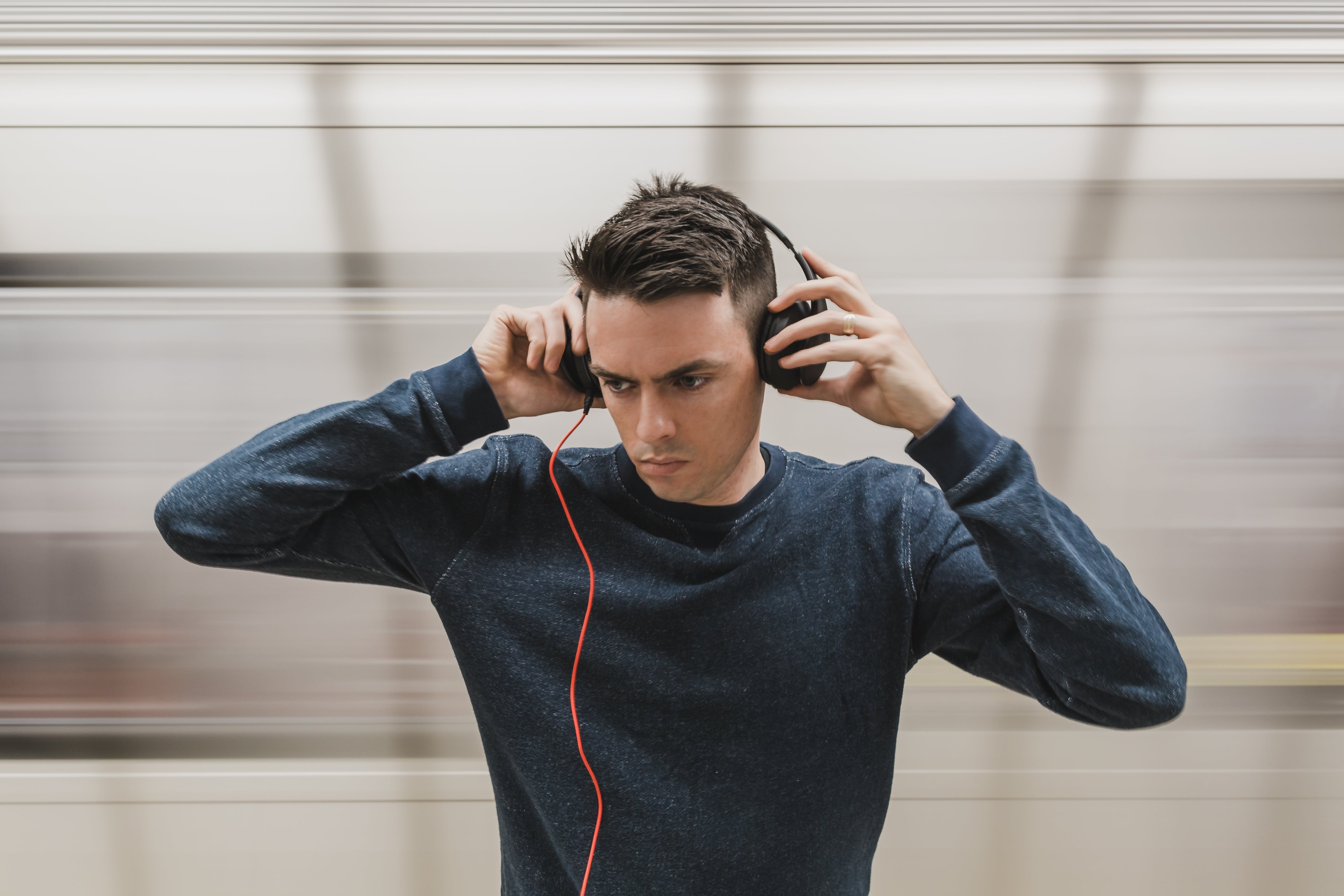 John listening to music. Парень в наушниках. Парень с наушниками. Молодой человек в наушниках. Наушники на человеке.