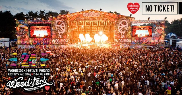 The crowd watches the stage as fire bursts from the center.